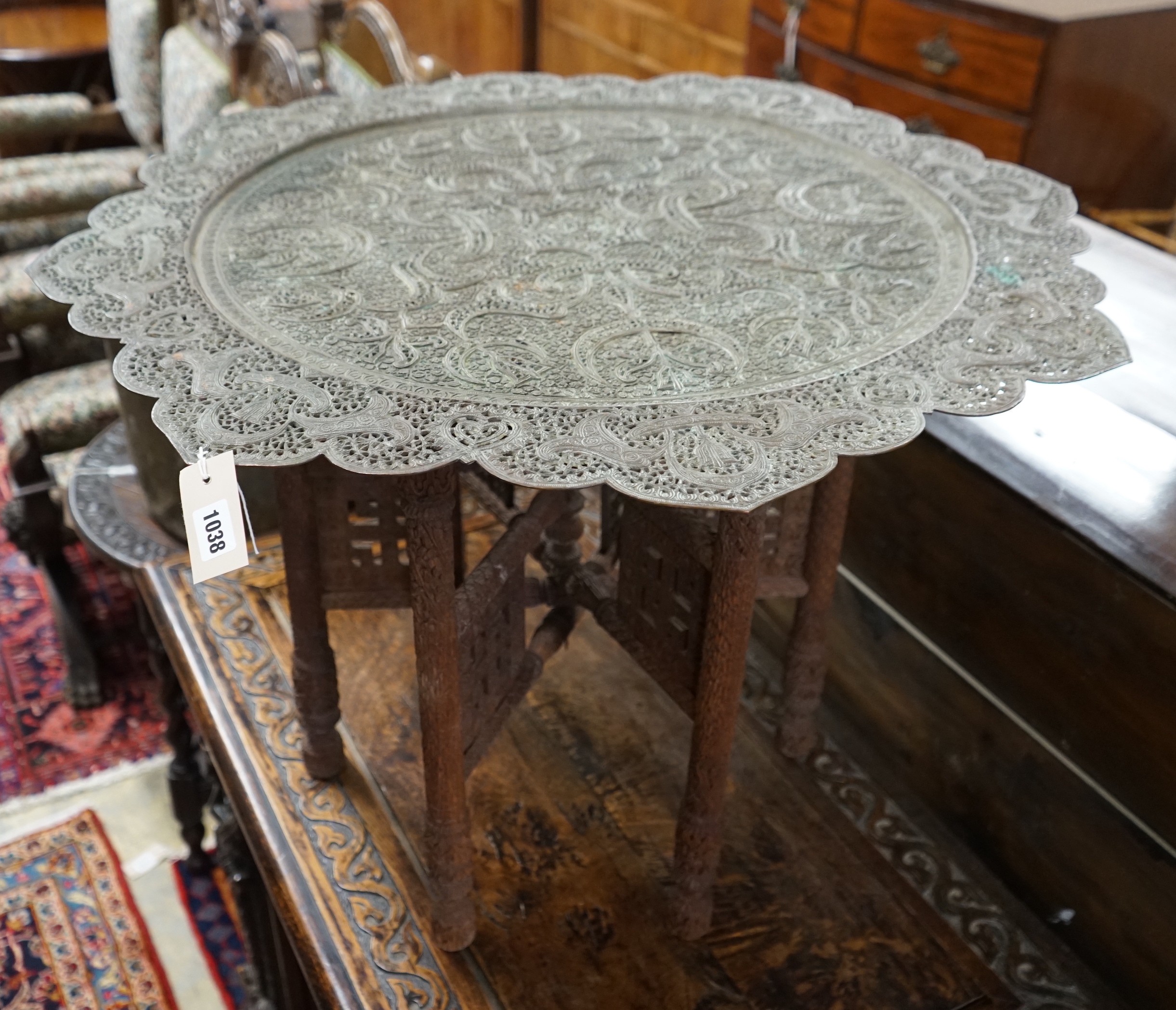 An Indian circular pierced brass tray top table, on carved folding stand, diameter 83cm, height 55cm